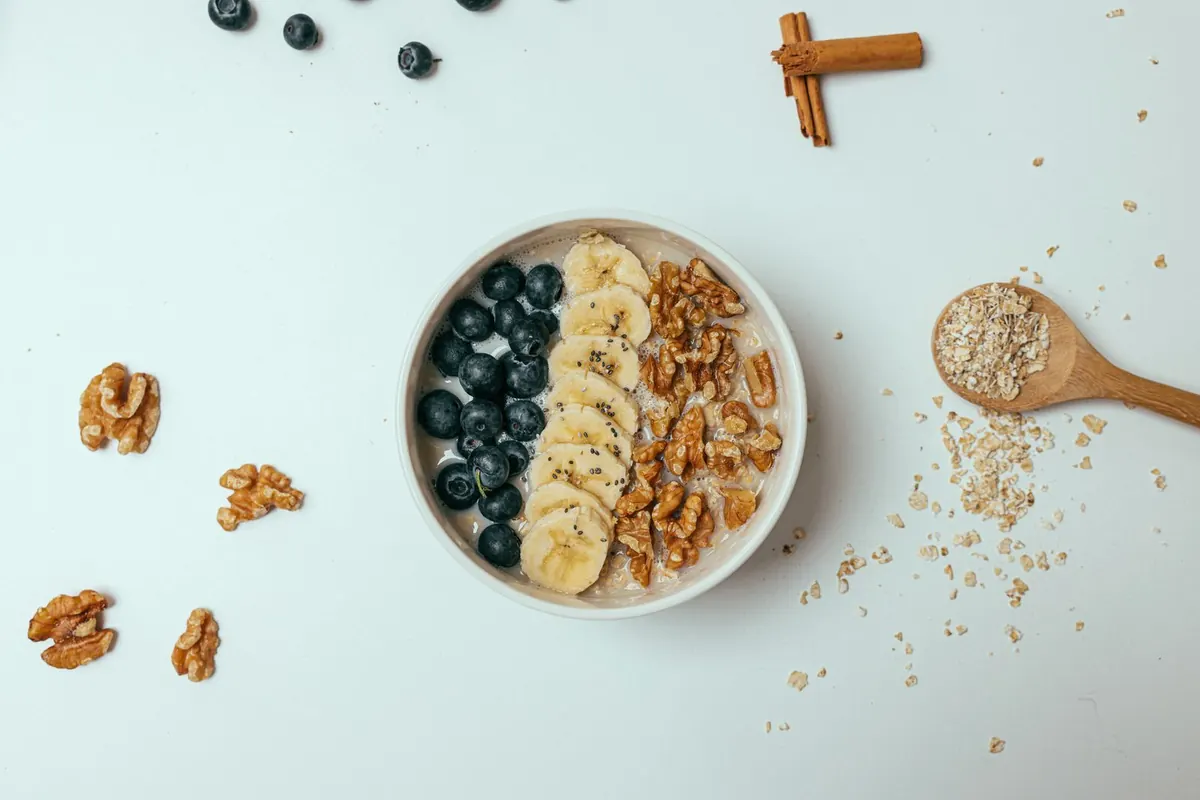 A bowl of porridge topped with banana, blueberries and seeds